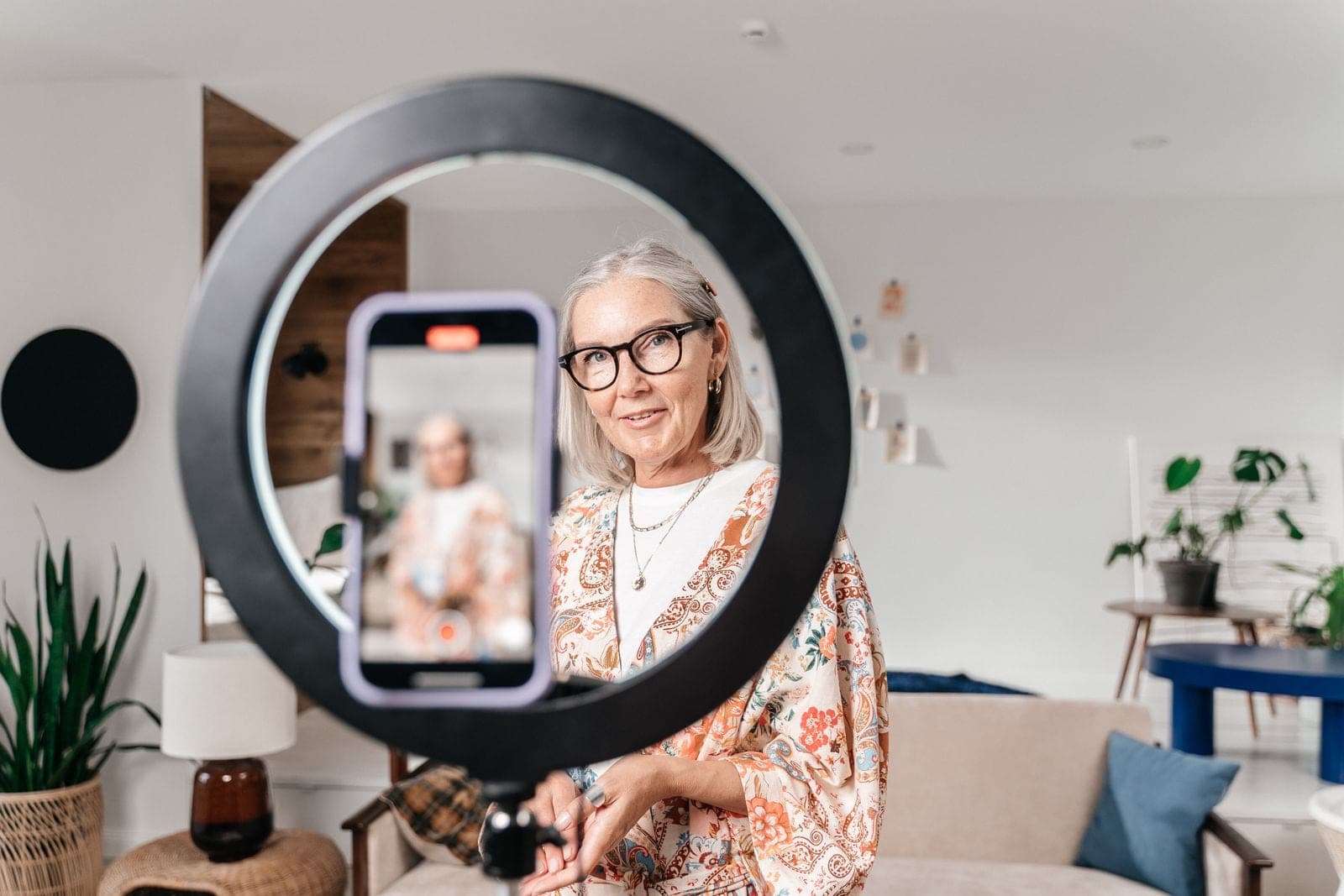 A professional recording a presentation with a smartphone and ring light