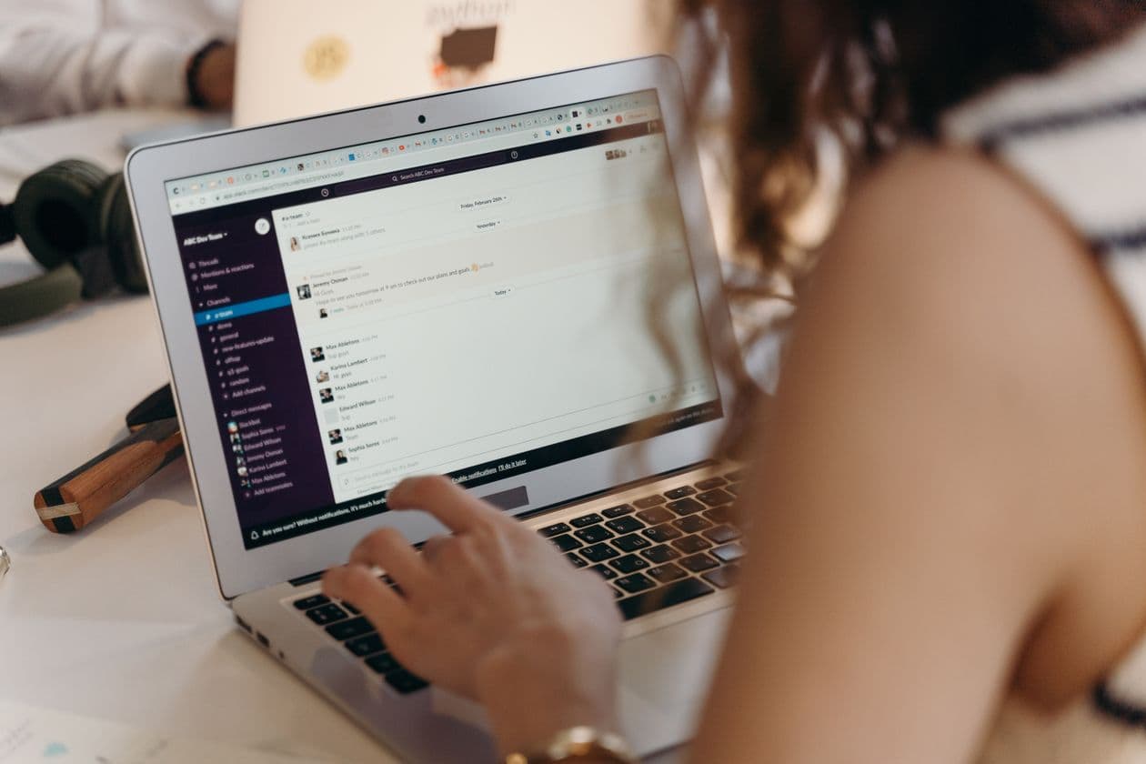 Professionnelle gérant ses communications numériques depuis un ordinateur portable